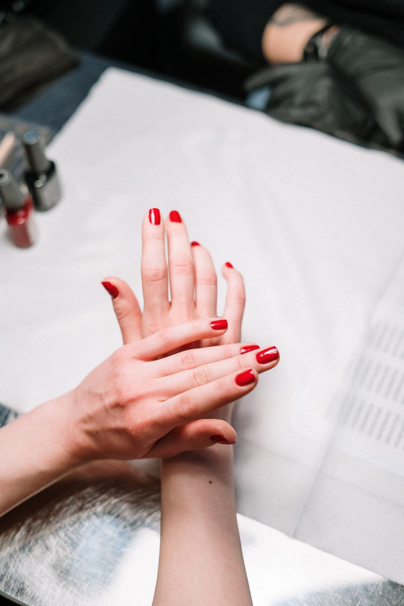 Nail technician applying red polish